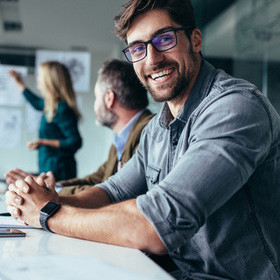Smiling designer sitting in board room during presentation